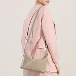 Back view of Cuirae gray genuine leather hobo bag worn on shoulder, showing adjustable strap details