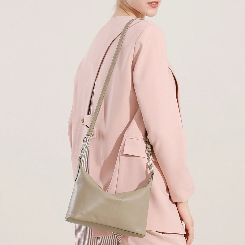 Back view of Cuirae gray genuine leather hobo bag worn on shoulder, showing adjustable strap details