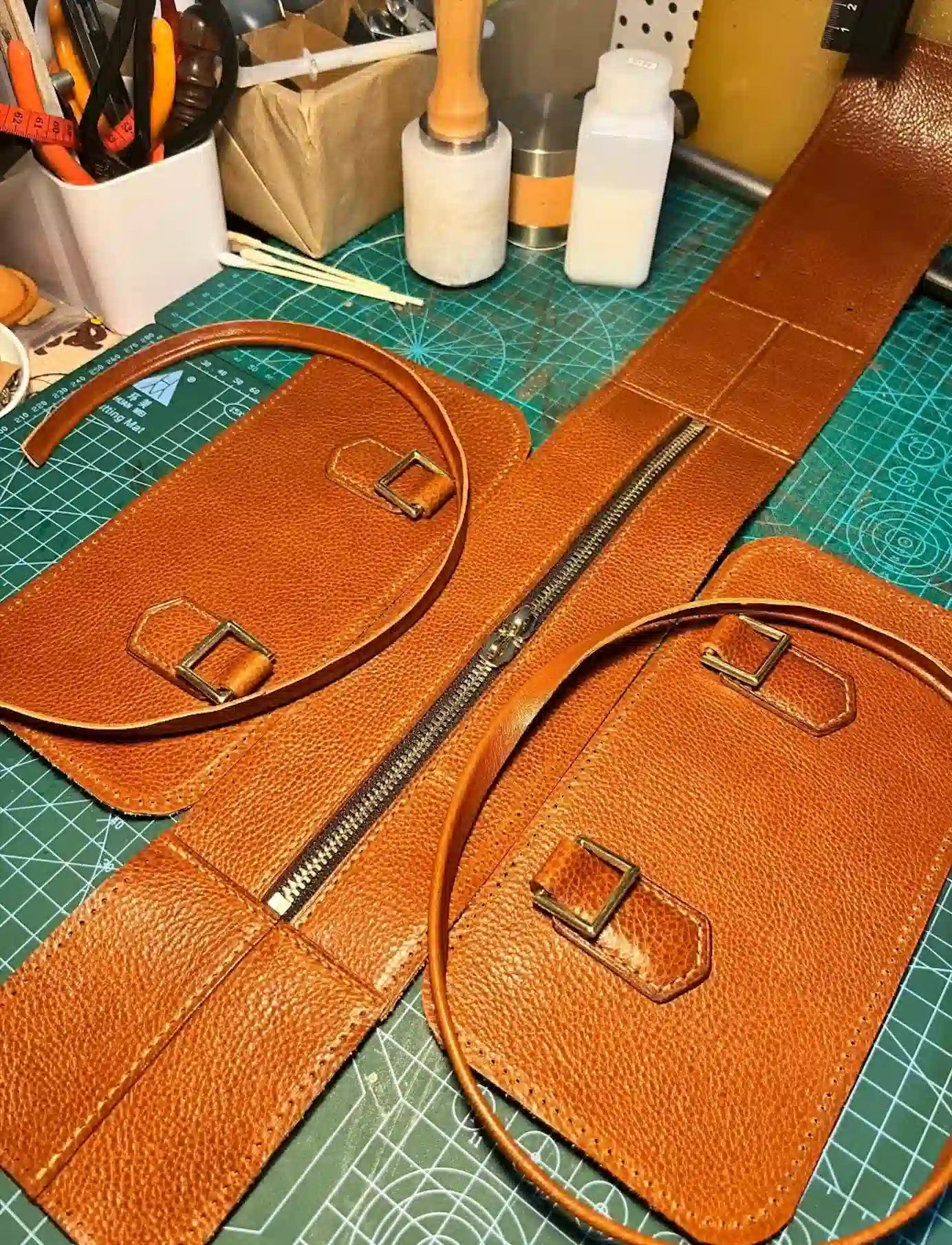 A Cuirae real leather bag being handcrafted on a workshop table with tools. No shortcuts, just expert craft.