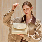 Model holding the Cuirae ivory pebbled leather flap crossbody bag