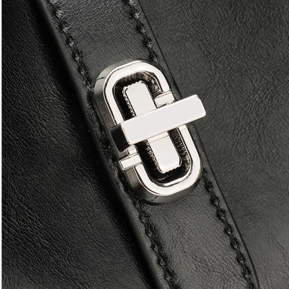 Close up of the sturdy silver turn lock closure and neat stitching on the Cuirae leather bag.