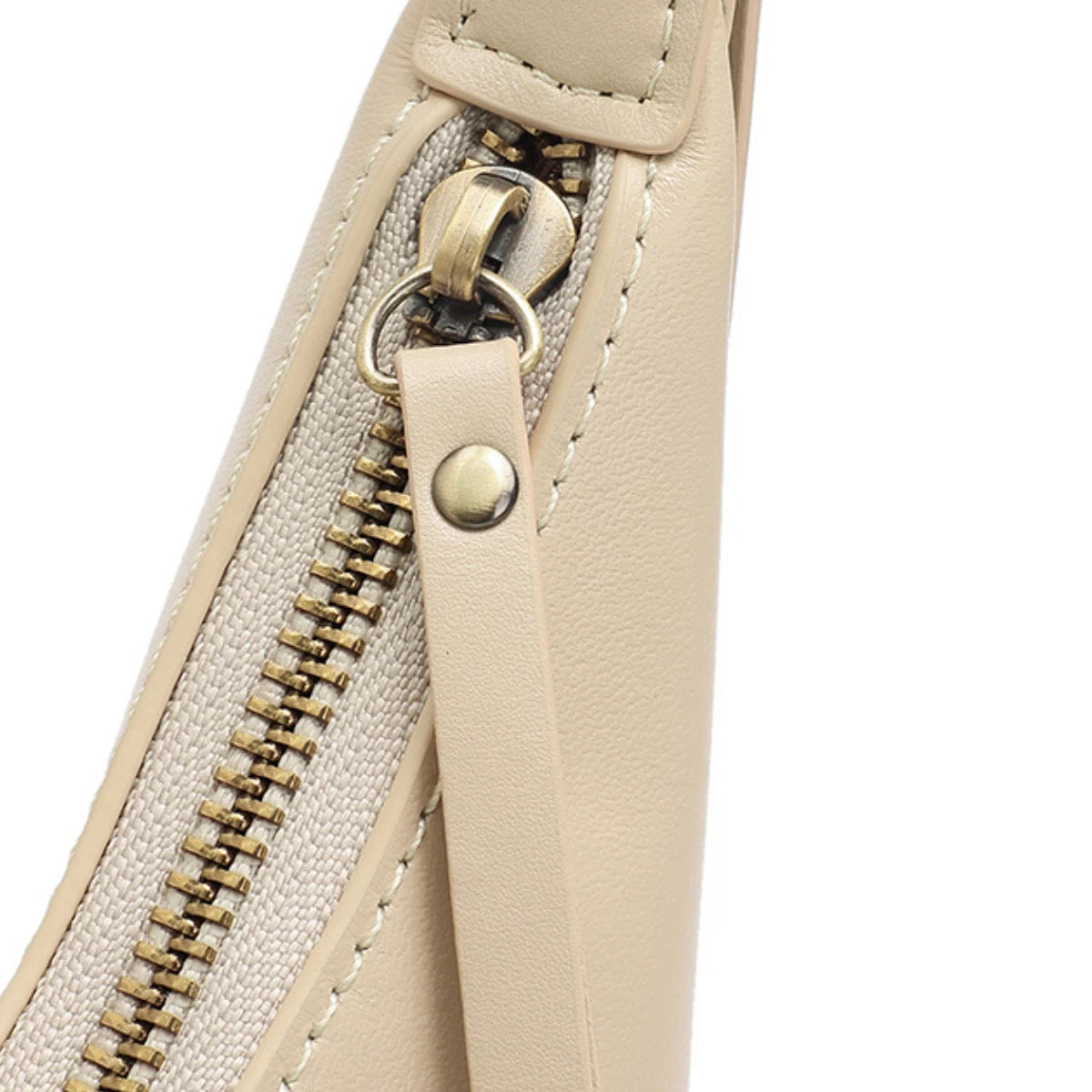 Close up of the smooth brass zipper and leather pull on the Cuirae handbag.