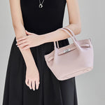 Model wearing Cuirae light pink pebbled leather kelly crossbody bag crossbody, front view showing silver turnlock hardware