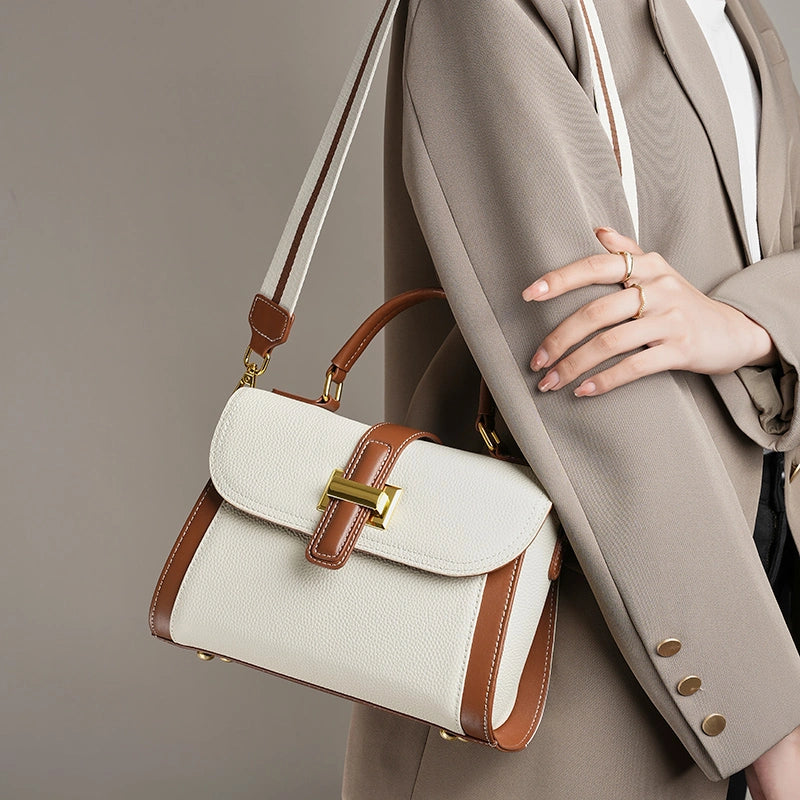 Model wearing Cuirae off-white and brown pebbled genuine leather shoulder bag, side view showing wide striped canvas strap