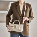 Cuirae off white genuine leather bowling crossbody bag worn on shoulder, front view showing structured silhouette and double pockets