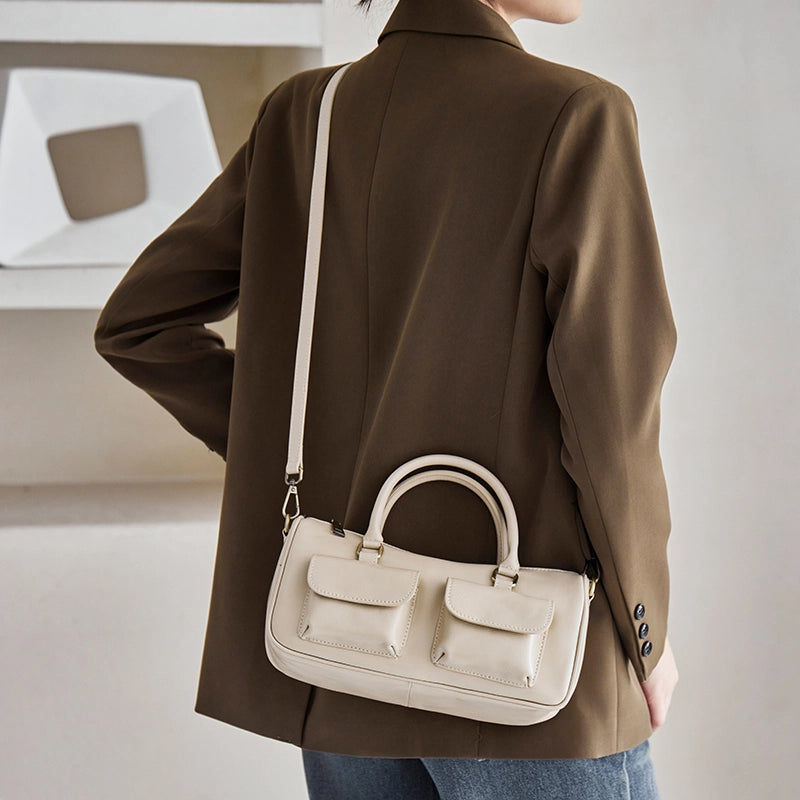 Back view of Cuirae off white genuine leather shoulder bag worn on shoulder, showing top handle and smooth leather texture