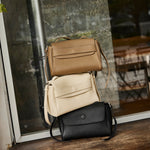 Cuirae pebbled leather flap shoulder bag shown in black, ivory, and gray