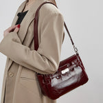 Woman wearing Cuirae red genuine leather crossbody bag on shoulder, side view highlighting structured silhouette