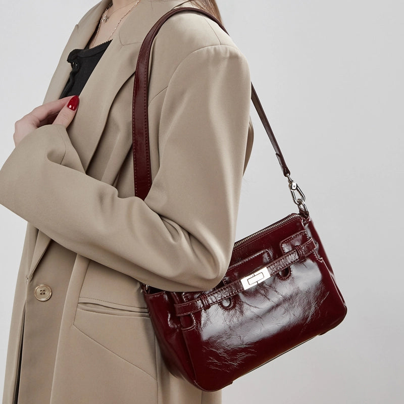 Woman wearing Cuirae red genuine leather crossbody bag on shoulder, side view highlighting structured silhouette