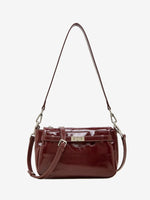 Cuirae red glossy genuine leather crossbody bag with turnlock detail and adjustable strap, front view on white background
