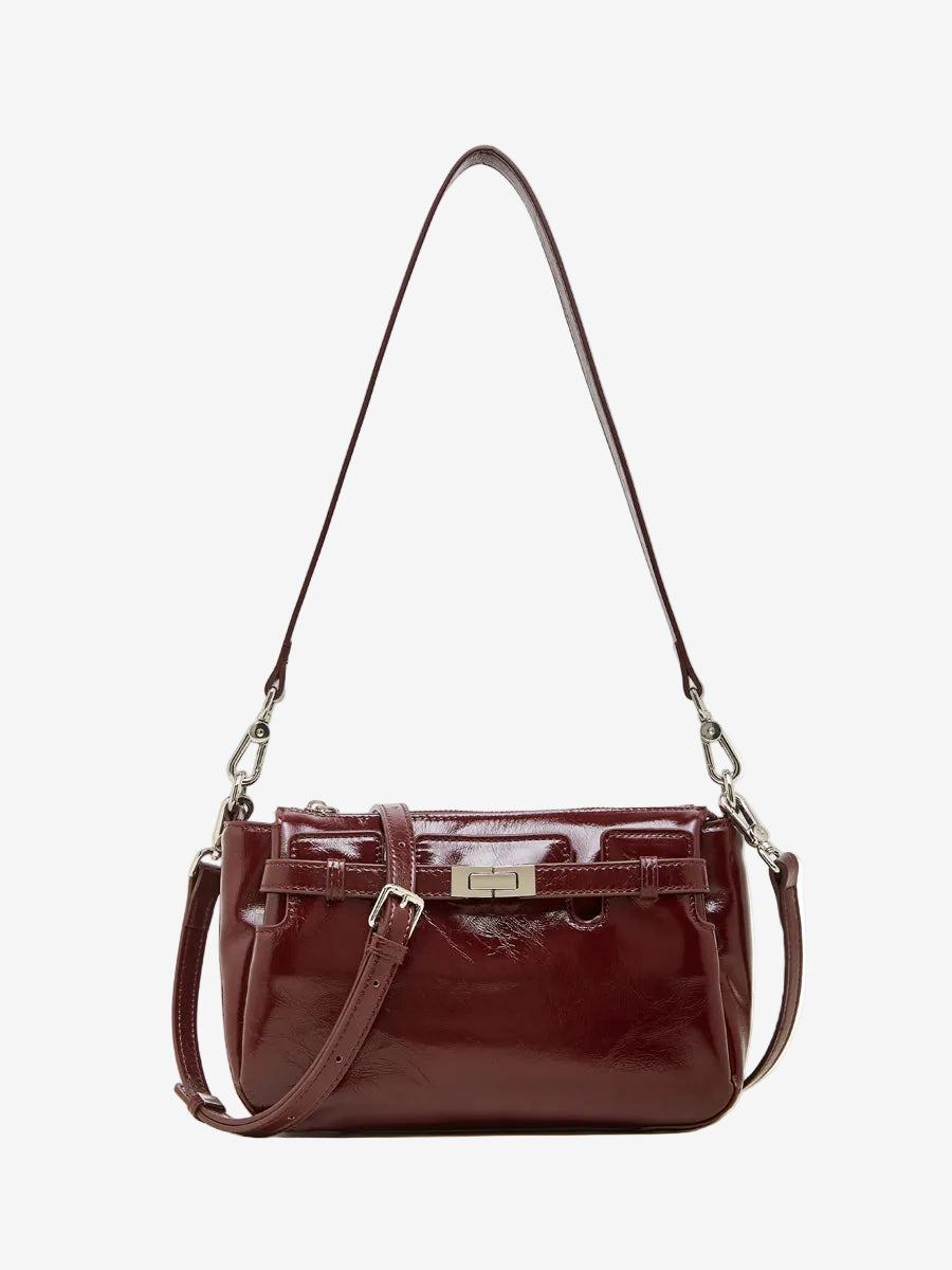 Cuirae red glossy genuine leather crossbody bag with turnlock detail and adjustable strap, front view on white background