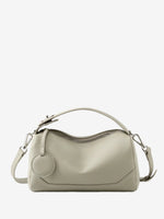 Cuirae stone pebbled genuine leather bowling handbag with round charm and silver hardware, front view on white background

