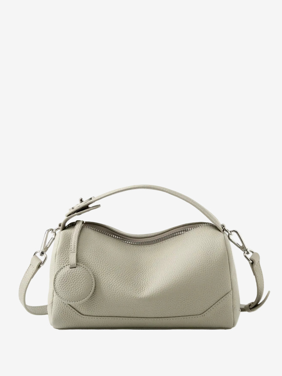 Cuirae stone pebbled genuine leather bowling handbag with round charm and silver hardware, front view on white background
