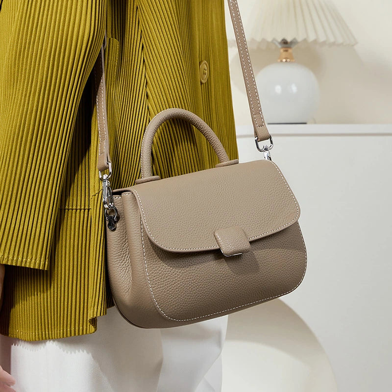 Cuirae taupe genuine leather crossbody saddle bag worn on shoulder, side view everyday style