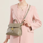 Model wearing Cuirae taupe genuine leather flap handbag crossbody, front view showing gold buckle and detachable strap