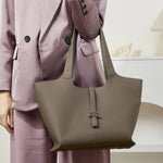 Close up of the Cuirae taupe genuine leather tote bag matching a work suit.