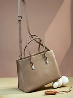 Taupe structured leather tote with an adjustable crossbody strap and silver-tone handle accents