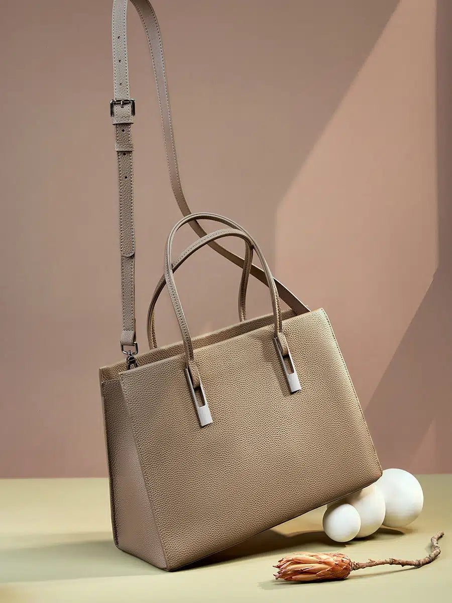 Taupe structured leather tote with an adjustable crossbody strap and silver-tone handle accents