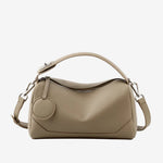 Cuirae taupe pebbled genuine leather bowling handbag with round charm and silver hardware, front view on white background