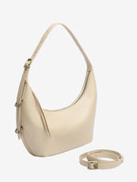 The Cuirae white genuine leather handbag sitting next to an extra strap on a plain white background.