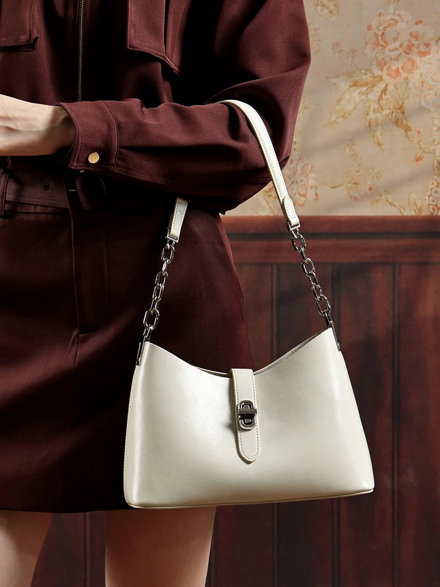 A close look at a woman wearing the Cuirae white top grain cowhide handbag on her shoulder.