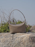 A dynamic showcase of the Cuirae genuine leather shoulder bag, highlighting its appearance up close and the details and metal hardware, as well as how the models demonstrate its versatility with various outfits.