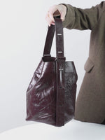 A dynamic showcase of the Cuirae genuine leather bucket bag, highlighting its appearance up close and the details and capacity, as well as how the models demonstrate its versatility with various outfits.