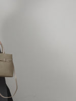 A dynamic showcase of the Cuirae genuine leather handbag, highlighting its spacious interior, built-in pockets, and metal hardware details, as well as how the models demonstrate its versatility with various outfits.