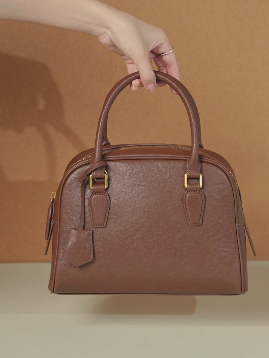 A dynamic showcase of the Cuirae genuine leather handbag, highlighting its appearance up close and the details and metal hardware, as well as how the models demonstrate its versatility with various outfits.