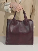 A dynamic showcase of the Cuirae genuine leather tote bag, highlighting its spacious interior, built-in pockets, and metal hardware details, as well as how the models demonstrate its versatility with various outfits.