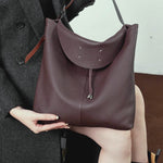 A dynamic showcase of the Cuirae genuine leather tote bag, highlighting its spacious interior, built-in pockets, and metal hardware details, as well as how the models demonstrate its versatility with various outfits.
