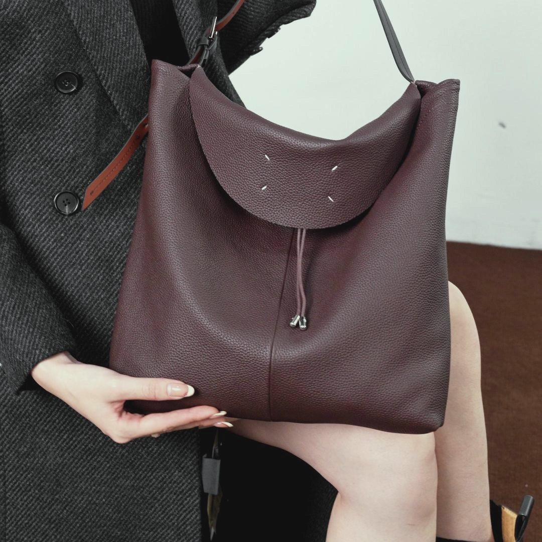 A dynamic showcase of the Cuirae genuine leather tote bag, highlighting its spacious interior, built-in pockets, and metal hardware details, as well as how the models demonstrate its versatility with various outfits.
