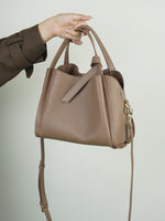 A dynamic showcase of the Cuirae genuine leather handbag, highlighting its spacious interior, built-in pockets, and metal hardware details, as well as how the models demonstrate its versatility with various outfits.