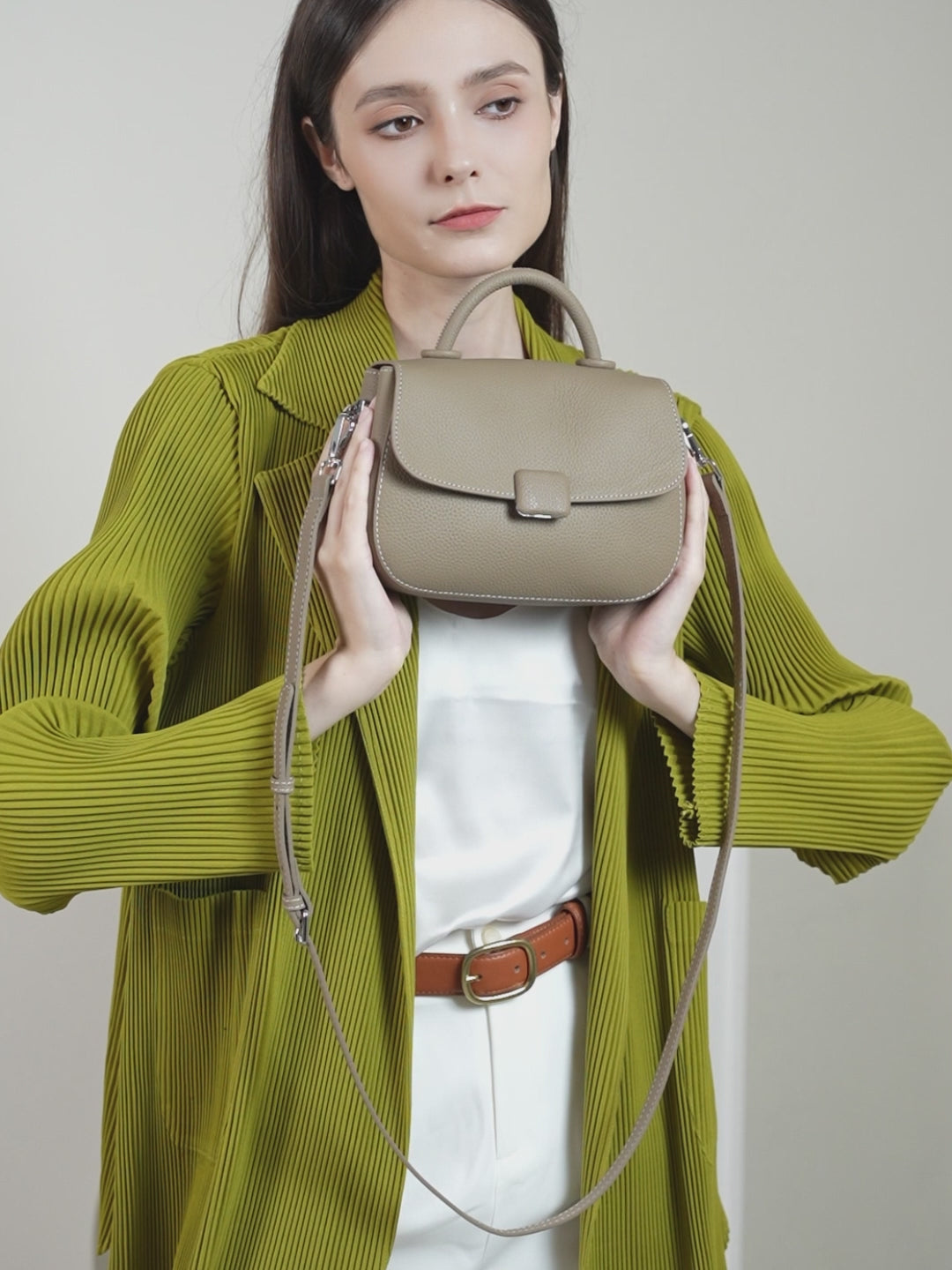 A dynamic showcase of the Cuirae genuine leather shoulder bag, highlighting its appearance up close and the details and metal hardware, as well as how the models demonstrate its versatility with various outfits.