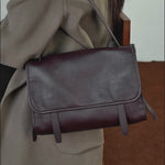 A dynamic showcase of the Cuirae genuine leather shoulder bag, highlighting its spacious interior, built-in pockets, and metal hardware details, as well as how the models demonstrate its versatility with various outfits.