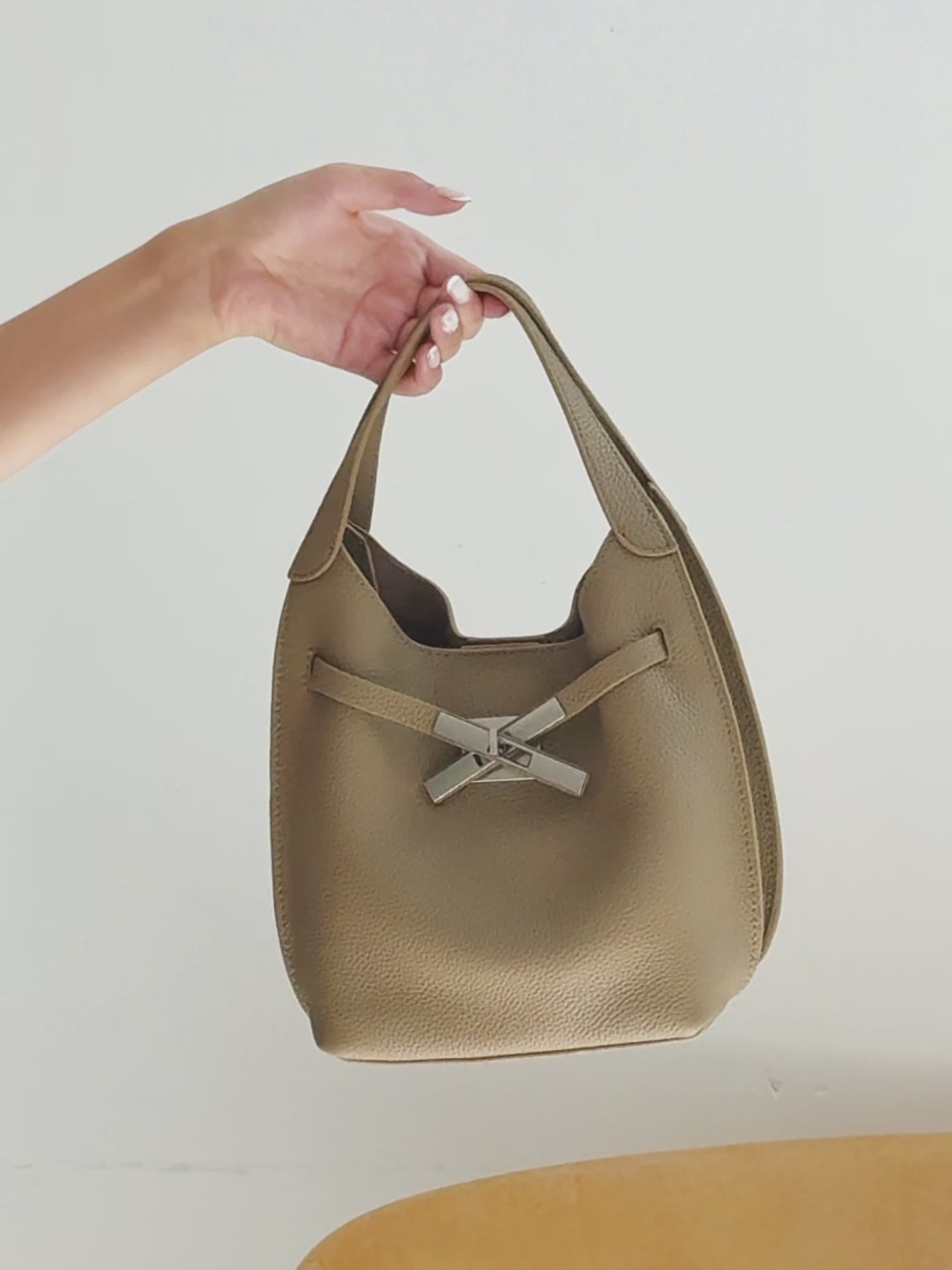 A dynamic showcase of the Cuirae genuine leather crossbody bag, highlighting its spacious interior, built-in pockets, and metal hardware details, as well as how the models demonstrate its versatility with various outfits.