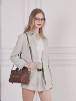  A video of a woman in a light jacket showing off the Cuirae brown top grain cowhide handbag. She wears it on her shoulder and holds it by the handles.