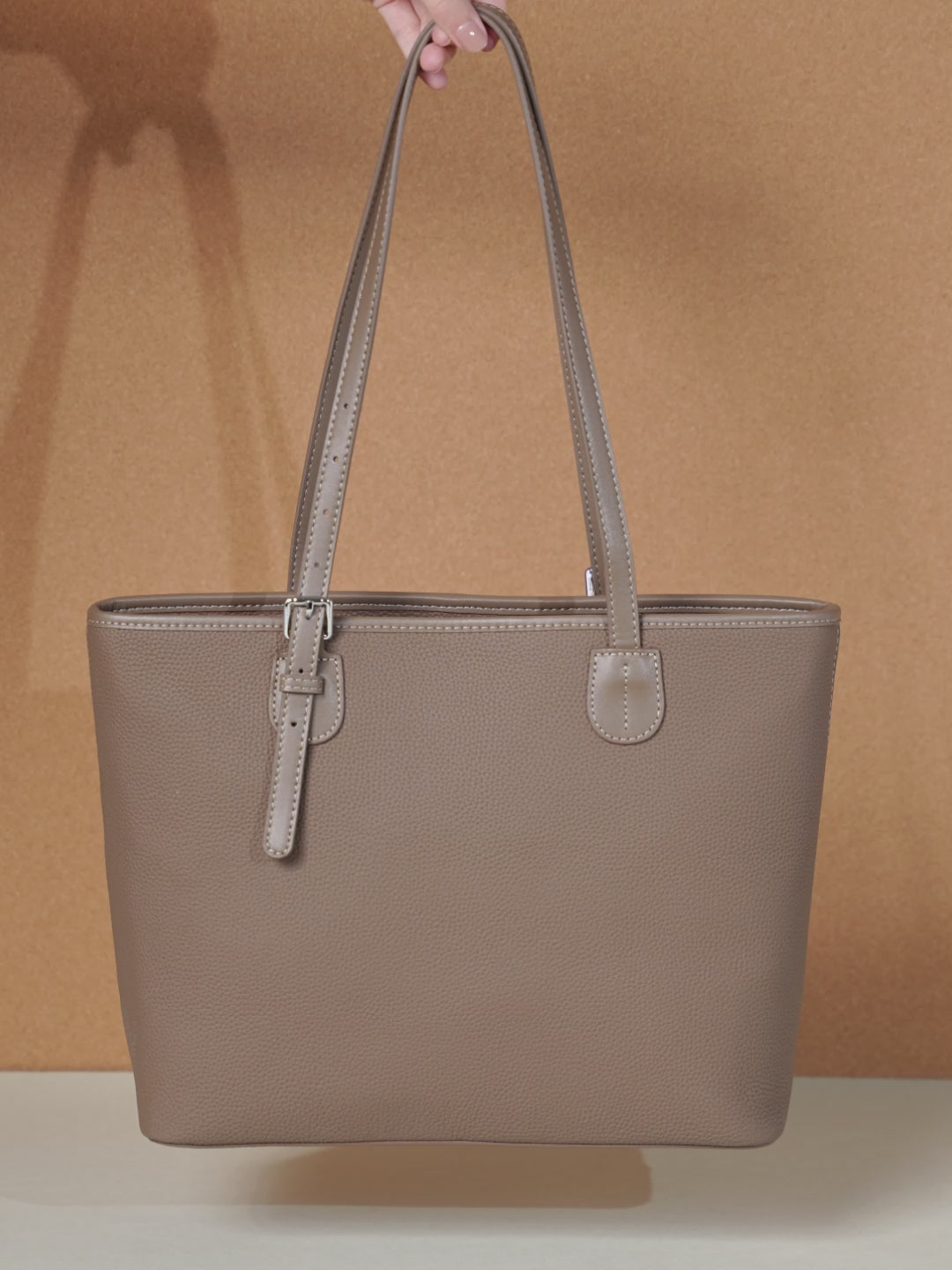 A dynamic showcase of the Cuirae genuine leather tote bag, highlighting its spacious interior, built-in pockets, and metal hardware details, as well as how the models demonstrate its versatility with various outfits.