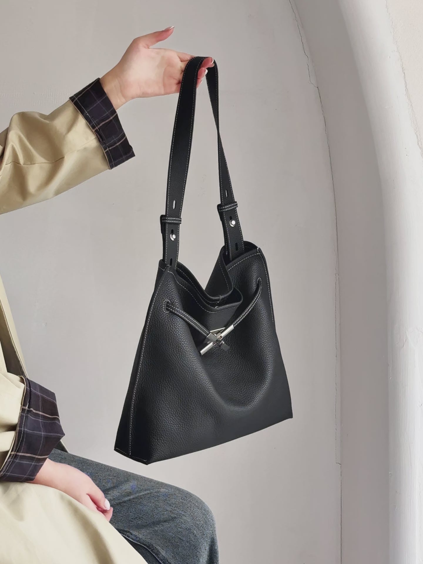 A dynamic showcase of the Cuirae genuine leather tote bag, highlighting its spacious interior, built-in pockets, and metal hardware details, as well as how the models demonstrate its versatility with various outfits.